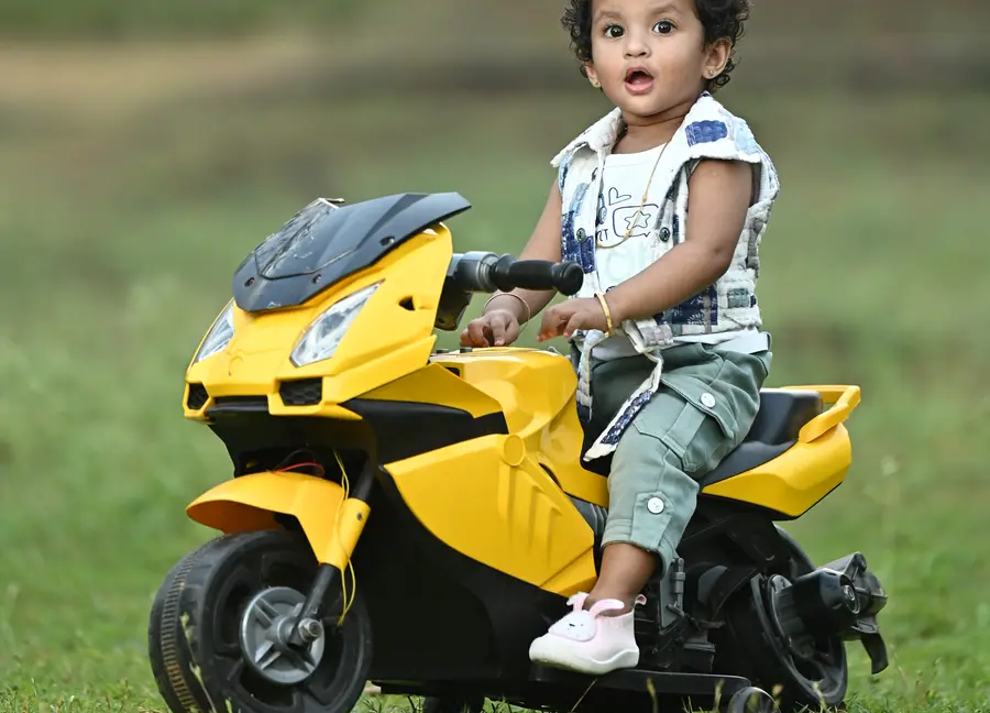 Child birthday portrait with a playful yellow bike prop