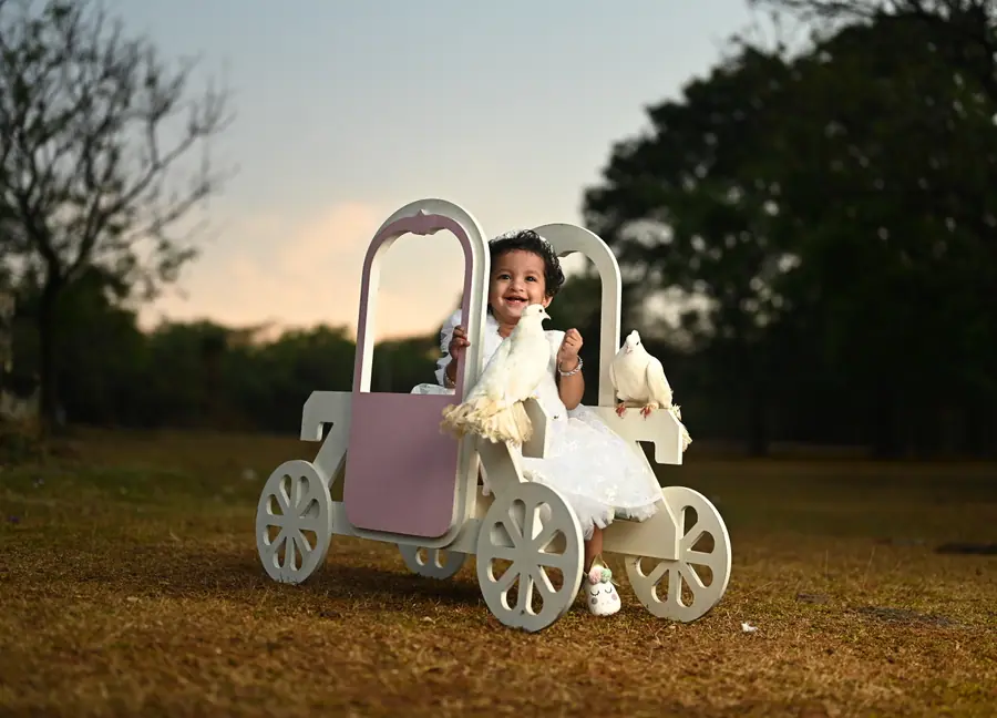 Child birthday portrait seated in a small carriage prop