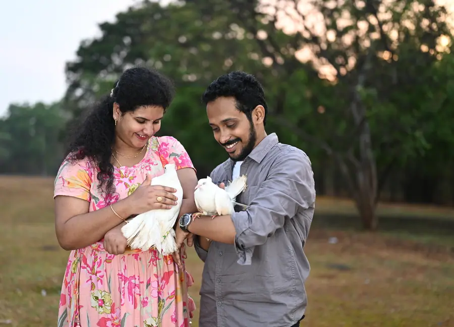 Couple holding white doves during an outdoor family shoot