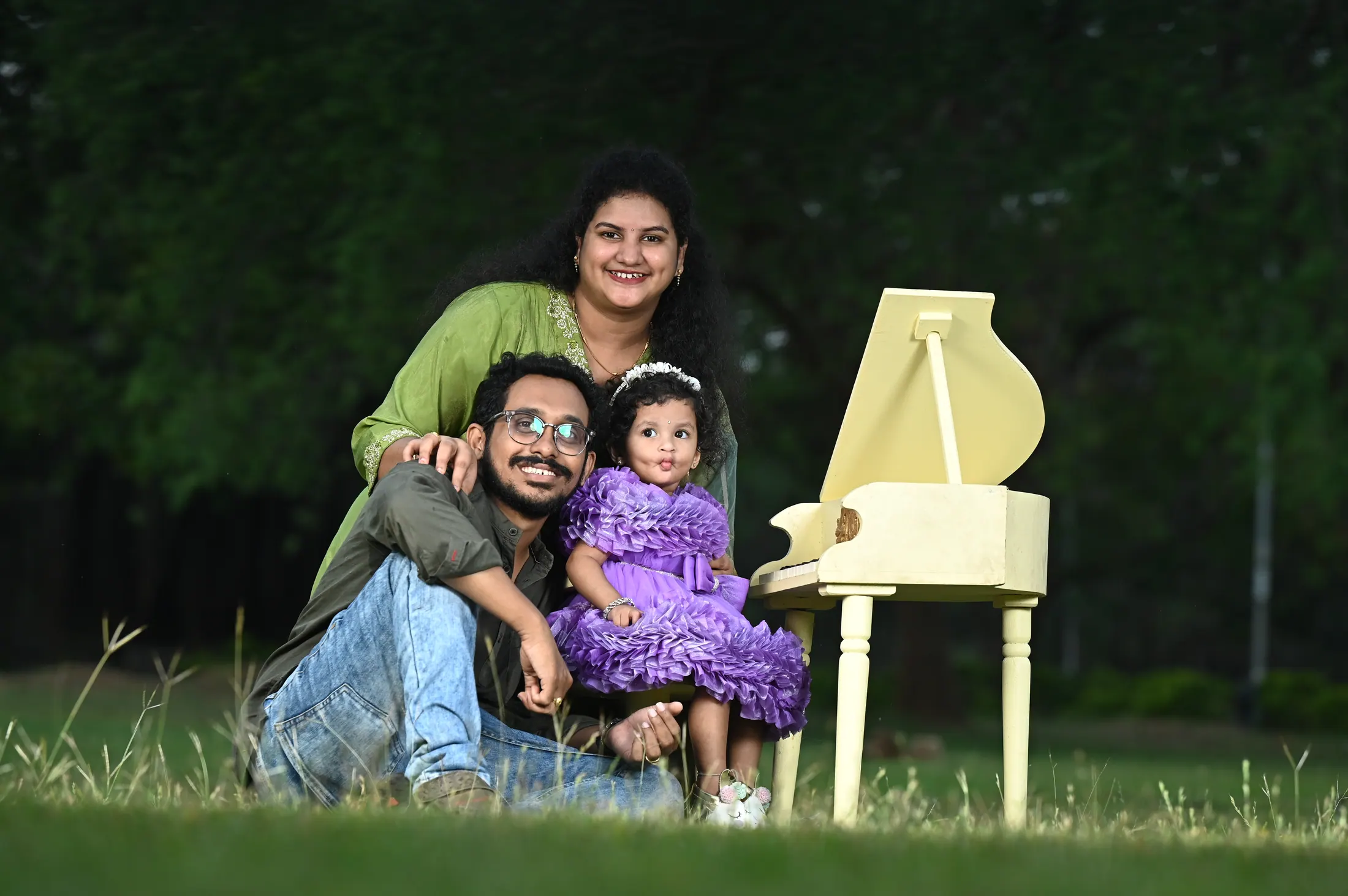 Family birthday portrait outdoors with a child in a purple dress