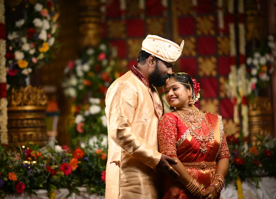 Bride and groom sharing a quiet wedding portrait on a decorated stage