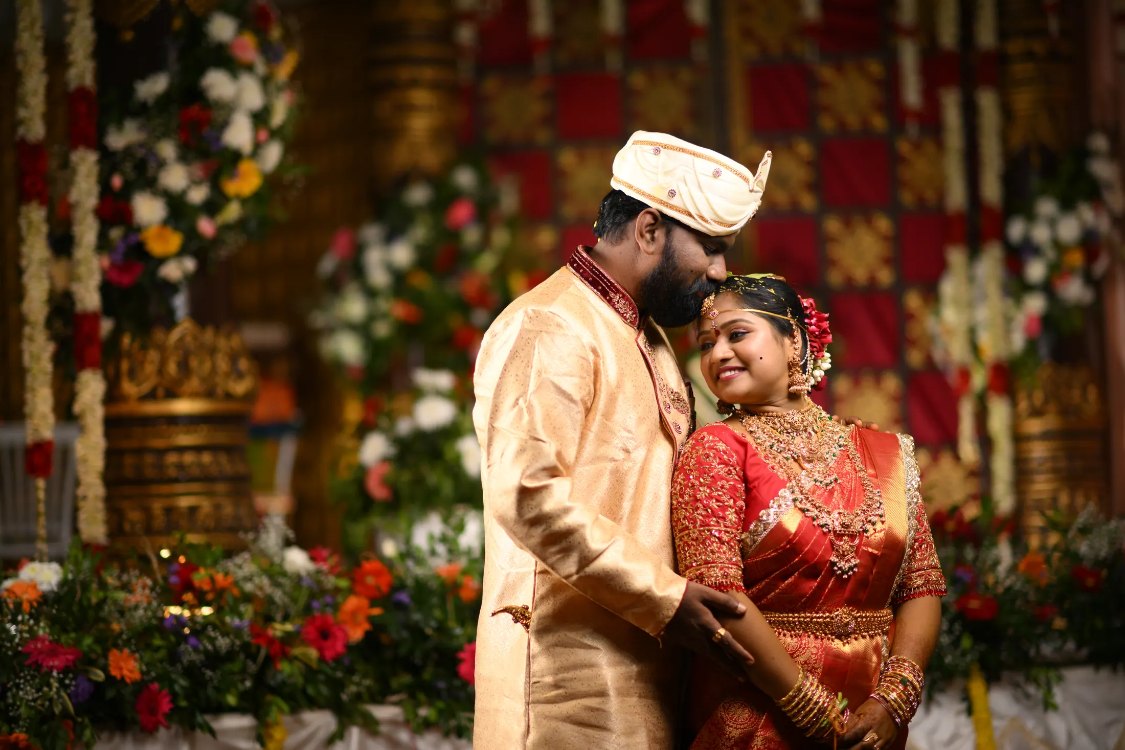 Bride and groom sharing a quiet wedding portrait on a decorated stage