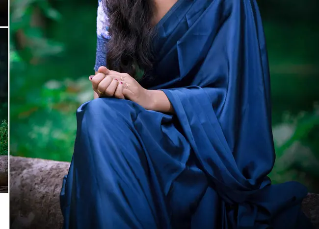 Pre-wedding portrait of a woman in a deep blue saree among trees