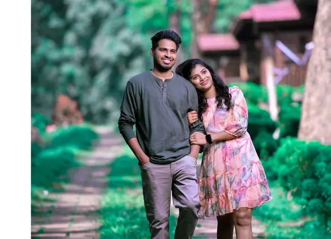 Pre-wedding couple on a green garden pathway