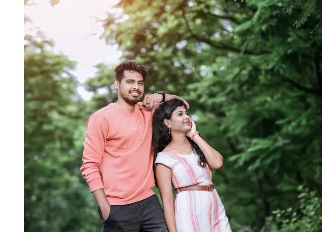 Pre-wedding couple on a tree-lined road in soft sunlight